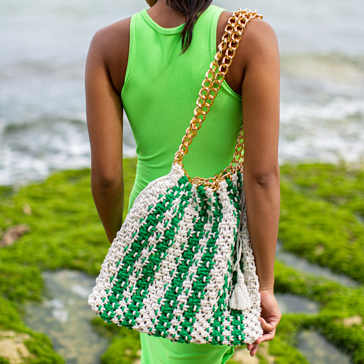 Colette macrame tote bag in Green and White. When Tenniscore meets Beachcore. Ideal for beach holidays, COLETTE has been hand-woven from a durable cotton rope with flattering chain straps and tasseled ties. It’s just the perfect to store all your beach essentials for a carefree island getaway. Wear yours with matching separates for an effortless beach look.