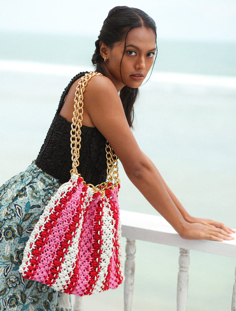 Colette macrame Tote Bag in Barbie Pink and Red. Ideal for beach holidays, COLETTE has been hand-woven from a durable cotton rope with flattering chain straps and tasseled ties. It’s just the perfect to store all your beach essentials for a care-free island getaway. Wear yours with matching separates for an effortless beach look.