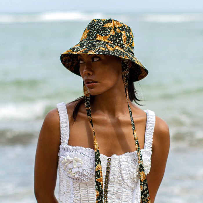 The Jasmine hat in Black and brown  is made meticulously of handpainted Batik fabric into a bucket silhouette with a medium dome-down brim to keep you under the shade during summer’s hottest days.  Made with light yet structural shape, the Jasmine hat is made to be your summer vacation essential. &nbsp;It has a packable design that makes it perfect for travel or storing in your beach bag.