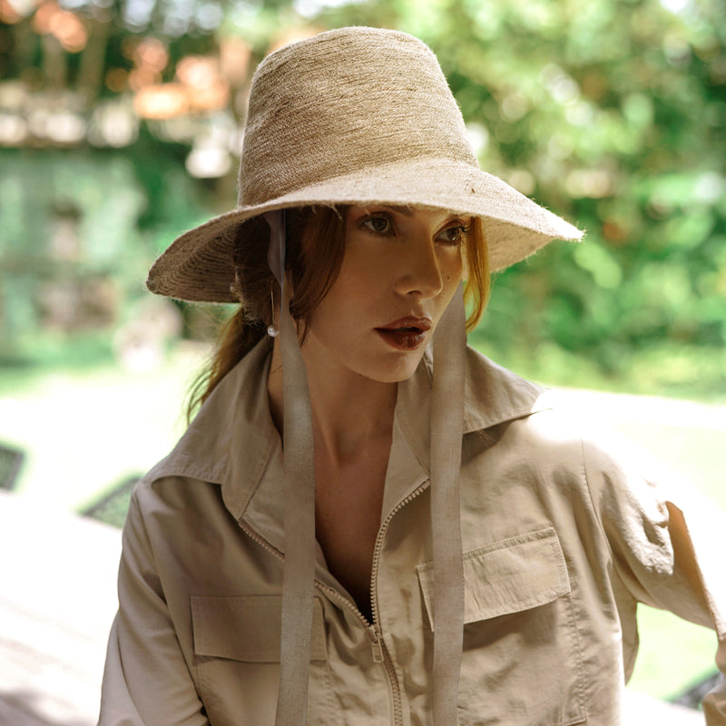 Meg Jute Straw Hat in Beige. Beautifully crafted with a tall crown shape and medium-width brim to bring back the effortless classic charm. Take this hat to your next outdoor adventure or simply to style up your daily grocery shop trips!