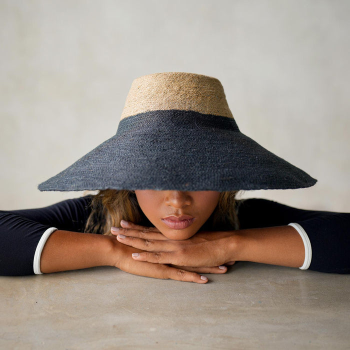 Duo color tone handwoven beach straw hat in natural and black brim color, handmade from natural jute straw by local artisan in Bali. Handmade vacation wide-brim hat with domed down brim for maximum sun protection. Sustainably made by female artisan community in Indonesia for resort vacation season.