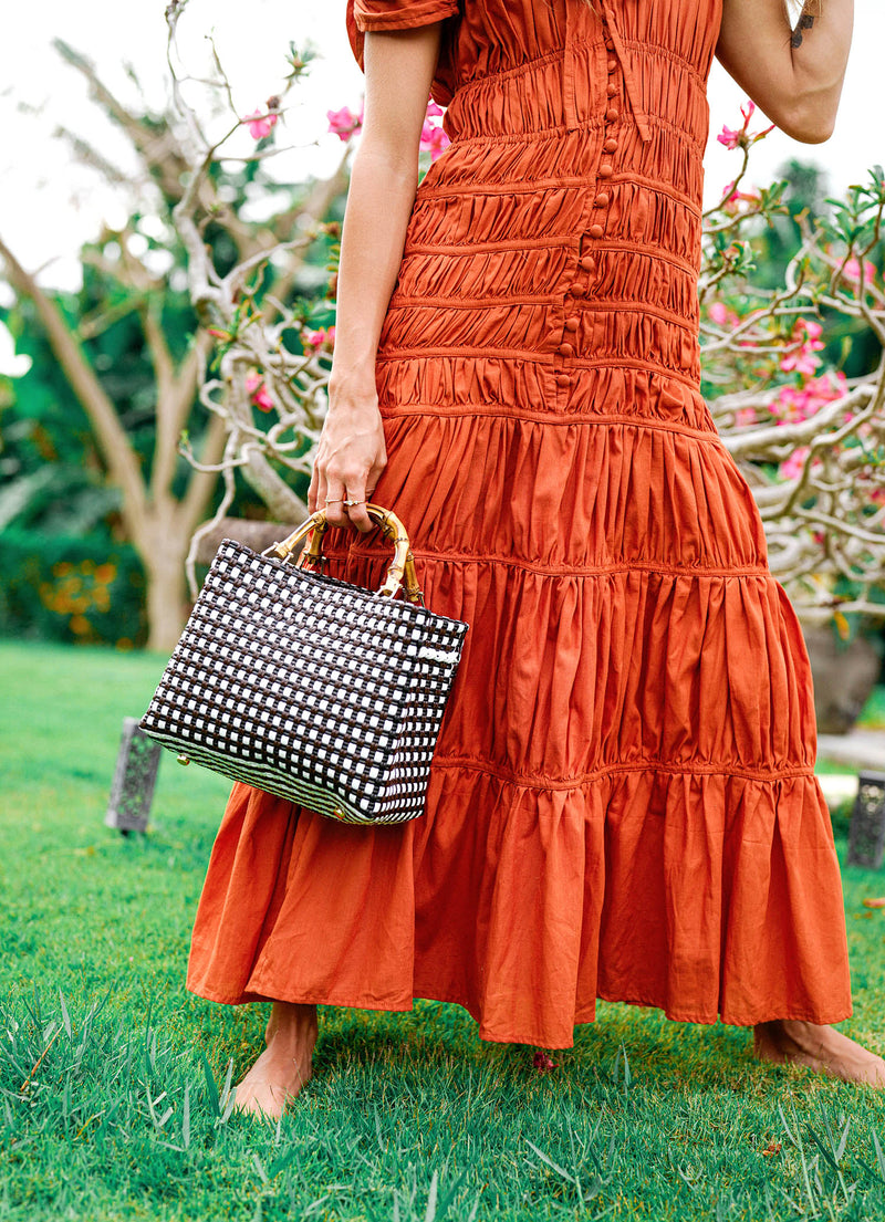 Inka Williams is wearing BrunnaCo's Sienna Brown Srikandi Ruffle Cocktail Dress in a beautiful day in Canggu, Bali, holding a recycled plastic tote bag. This shot is beautifully taken by Faruq Adib from Matarasa Indonesia