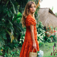 Inka Williams is wearing BrunnaCo's Sienna Brown Srikandi Ruffle Cocktail Dress in a beautiful day in Canggu, Bali, holding a dazzling gold tote bag