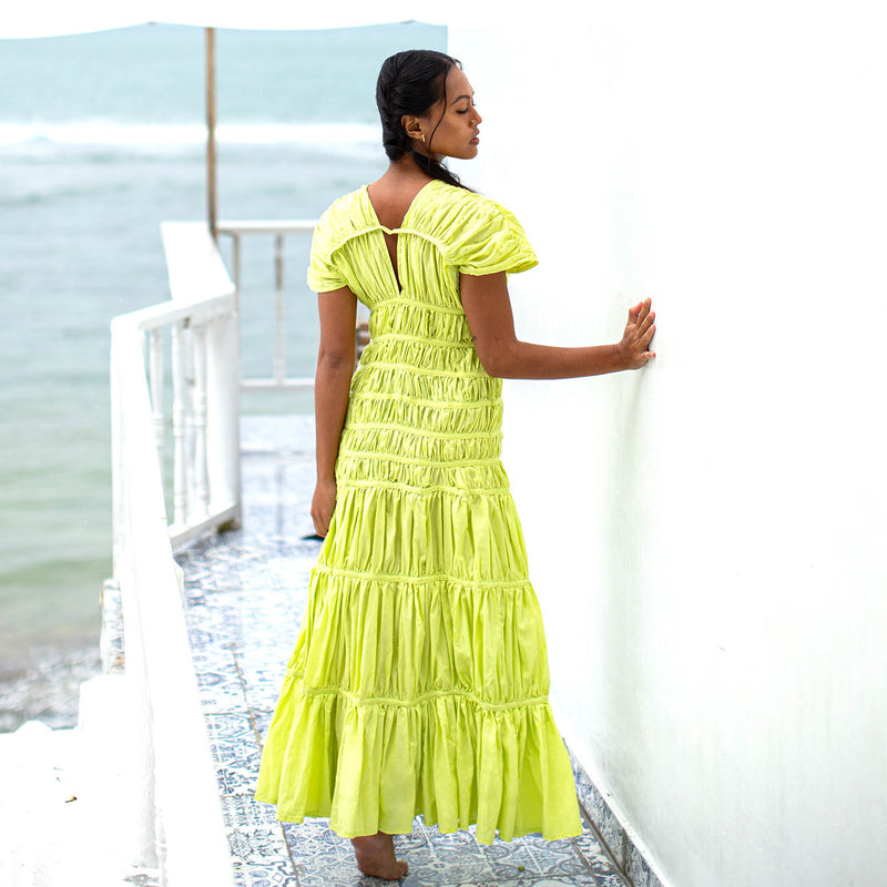 A women wearing elegant long dress by BrunnaCo called SRIKANDI Ruffle Maxi Dress In Lime Green