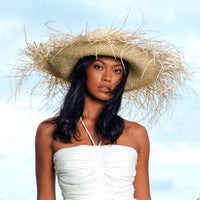 BrunnaCo Catalina Frayed Straw Hat. Meet Catalina, the timeless beauty, with an edge. Made entirely of straw, this mesmerizing sun hat has a wide brim and a frayed edge. Thoughtfully made by artisan communities in Java, from locally harvested straws. Wear it like a crown - with your resort dresses and swimsuits for a perfect romantic getaway.