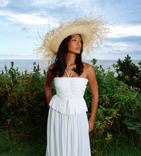 BrunnaCo Catalina Frayed Straw Hat. Meet Catalina, the timeless beauty, with an edge. Made entirely of straw, this mesmerizing sun hat has a wide brim and a frayed edge. Thoughtfully made by artisan communities in Java, from locally harvested straws. Wear it like a crown - with your resort dresses and swimsuits for a perfect romantic getaway.