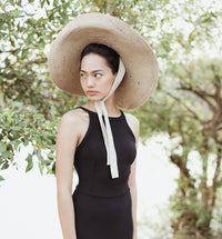 Lola Wide Brim Jute Straw Hat In Natural Beige. This sun hat is hand-weaved meticulously by women artisans in Gianyar, Bali from natural Jute material, this sweet hat offers both comfort and elegance. Designed with ideal thickness and weight that allow its brim to be easily folded, stretched, and styled, making it easy to take to any holiday trip. 