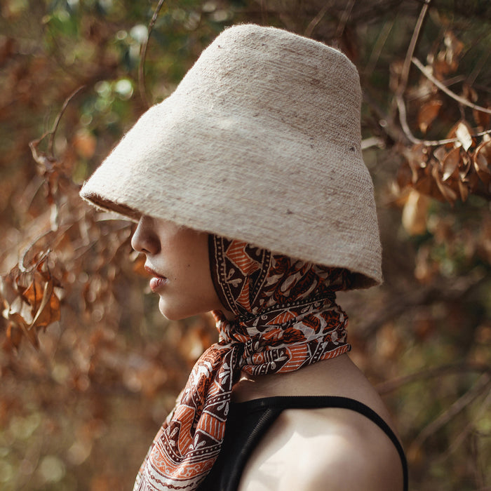 Naomi Jute Straw hat in Beige. Naomi Jute Bucket Hat is designed specifically for the wild at heart with classic sophistication. Enjoy lounging poolside or exploring the city on sun-soaked days as its protective hat brim provides ample shade. Made of natural jute straws which have the perfect weight, this hat will sit comfortably and won't fly away in sudden gusts. It's also very practical to pack in any size luggages and ideal to take on any trips.