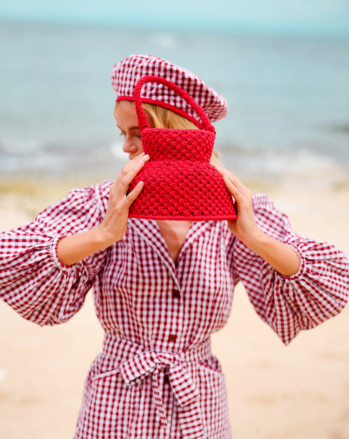 Petite Naga Macrame Crochet Bucket Beach Bag in Red. Petite Naga Macrame Crochet Bucket Beach Bag in Red. This bucket bag is made with hand-dyed macrame cotton ropes by our female artisan community in Java, Indonesia. It takes at least around 80 hours to make each bag, and this project helps to provide jobs and security for the artisans in this region.