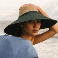 Duo color tone handwoven beach straw hat in natural and black brim color, handmade from natural jute straw by local artisan in Bali. Handmade vacation wide-brim hat with domed down brim for maximum sun protection. Sustainably made by female artisan community in Indonesia for resort vacation season.