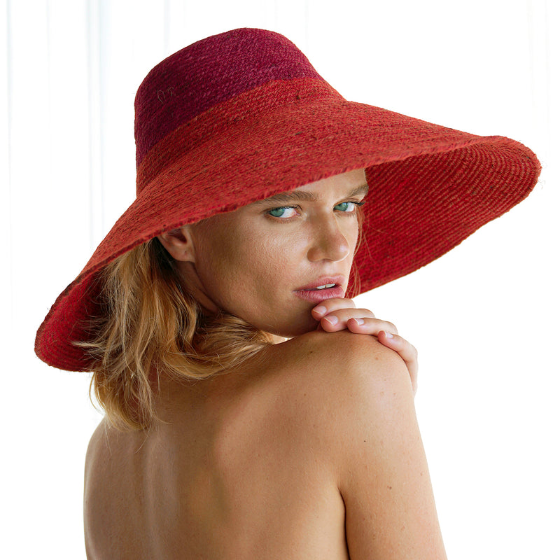 Duo color tone handwoven beach straw hat in red and maroon brim color, handmade from natural jute straw by local artisan in Bali. Handmade vacation wide-brim hat with domed down brim for maximum sun protection. Sustainably made by female artisan community in Indonesia for resort vacation season.