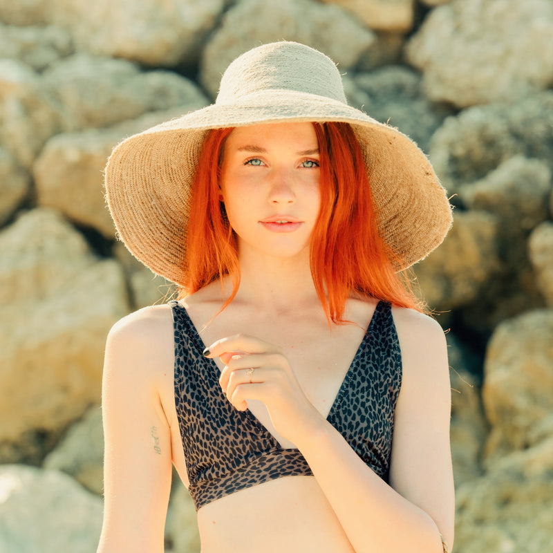 Don't be afraid of the sun. Step out in confidence with this ultra-comfortable Riri Jute woven sun hat in natural beige color. Take this artisanal hat everywhere from the sunny beachside to the hot savanna of your choice and enjoy full-on protection under the sun, while still keeping in style. This sustainable resort vacation straw hat is uniquely made by artisans in Bali.