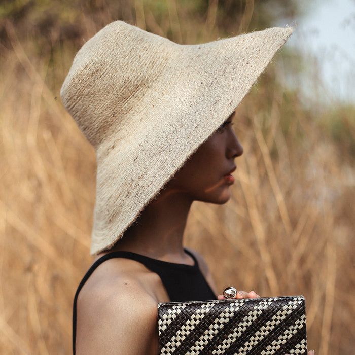 Don't be afraid of the sun. Step out in confidence with this ultra-comfortable Riri Jute woven sun hat in natural beige color. Take this artisanal hat everywhere from the sunny beachside to the hot savanna of your choice and enjoy full-on protection under the sun, while still keeping in style. This sustainable resort vacation straw hat is uniquely made by artisans in Bali.