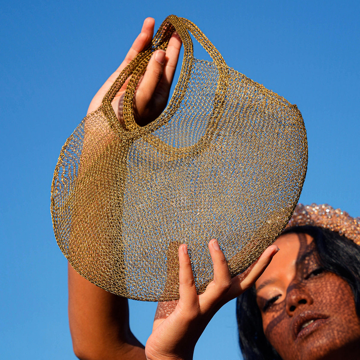 BrunnaCo Artisanan SOL Wire Tote Beach Bag in Dark Gold. Precious handwoven tote bag made from stainless metal wire. Made carefully by our artisans in remote villages in Bali, who create the bags from their very own homes. It is a true masterpiece.