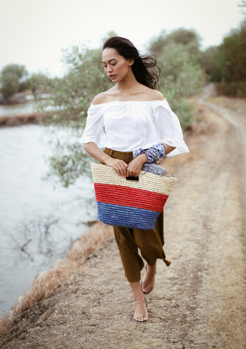 BrunnaCo Sayan Raffia Woven Straw Tote Bag in Red and Blue. A raffia beach tote that is perfect for any beach stroll or a casual walk to the nearest farmer's market